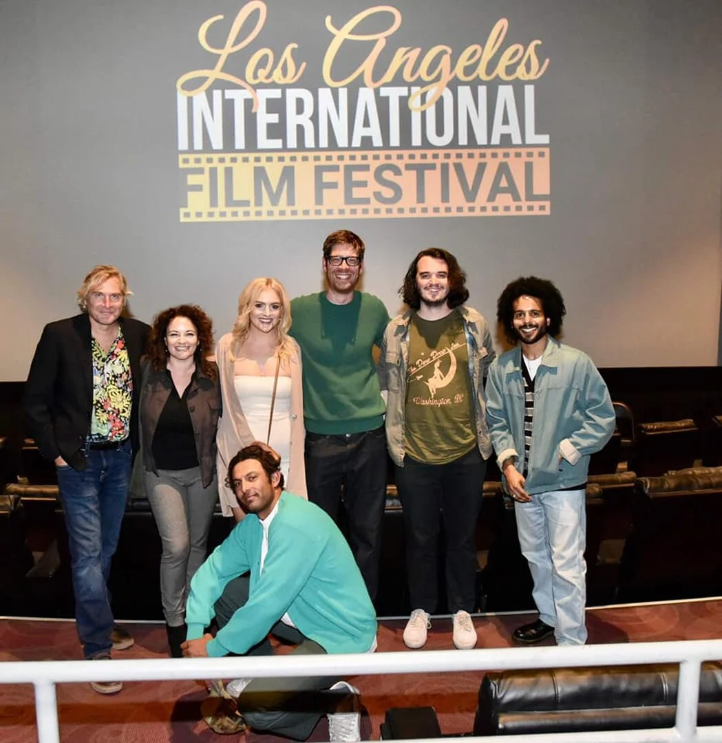 Filmmakers gathering on stage beneath the LAIFF logo